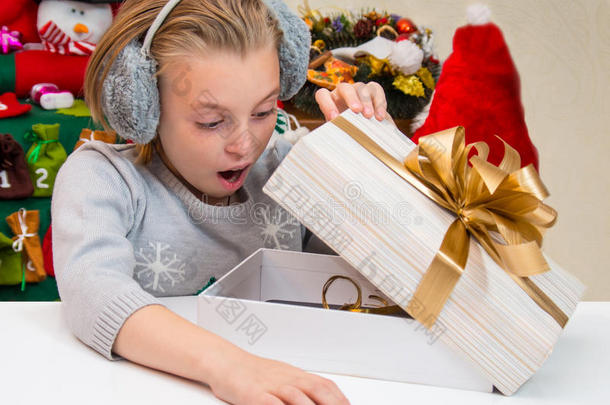 圣诞节的时候，孩子在一个装有礼物的盒子里看着。