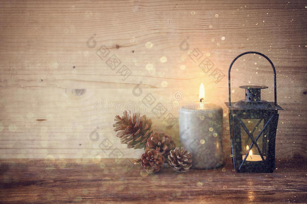 <strong>复古灯</strong>笼与燃烧的蜡烛，松果木桌和闪光的背景。过滤后的图像