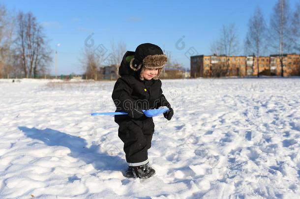 两岁的小<strong>男孩</strong>在冬天用铲子<strong>走路</strong>