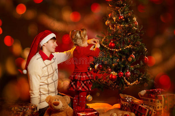 家庭装饰圣诞树。父亲和孩子庆祝圣诞节