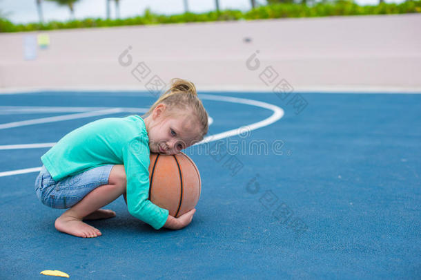 热带球场上带着篮球的小女孩