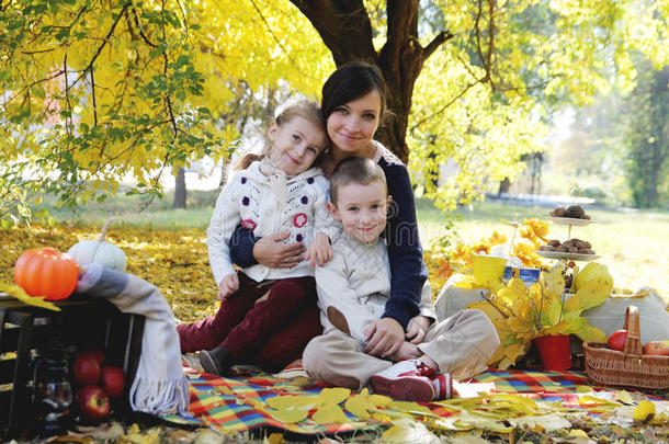 母亲带着儿子和女儿在秋树下