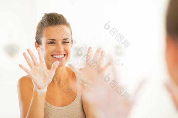 一个年轻的女人伸着肥皂水的手