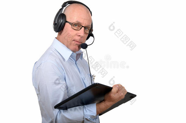 一个拿着数字平板电脑和耳机工作的中年男子