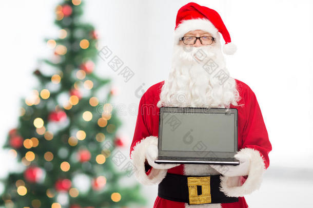 圣诞老人<strong>装扮</strong>的男人拿着笔记本电脑