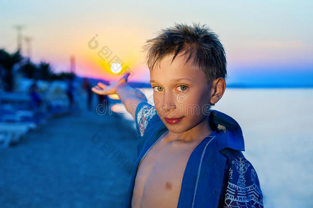 暑假日落时站在海滩上的美丽有趣的孩子