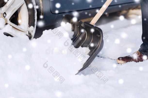 车旁铲雪男子特写