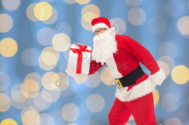 圣诞老人<strong>装扮</strong>的男人拿着礼品盒