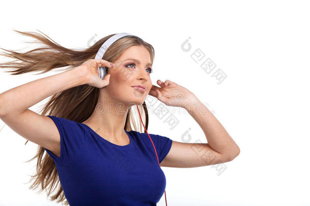 戴着耳机听音乐的快乐的年轻女子。