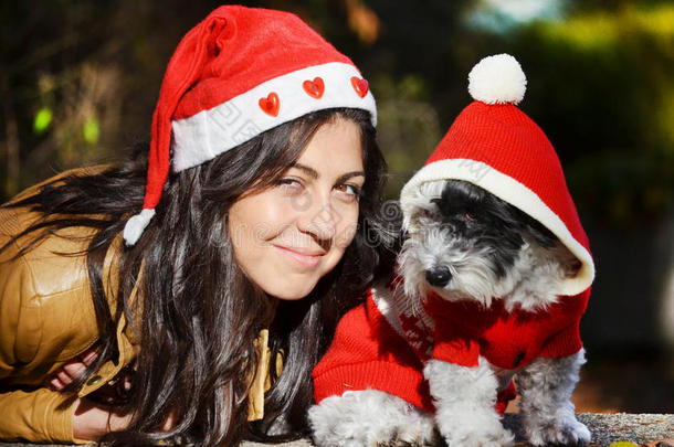 戴着红色圣诞帽的女人在遛狗