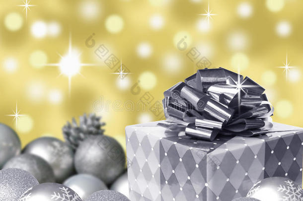 银色礼品蝴蝶结和圣诞球与雪花和金色抽象博克背景