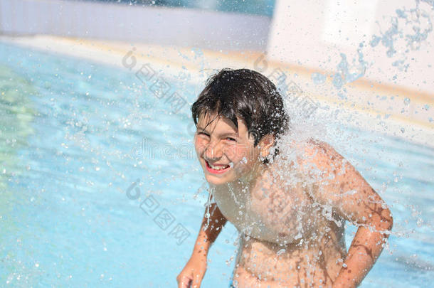 夏天，小男孩在游泳池里强劲的水流下