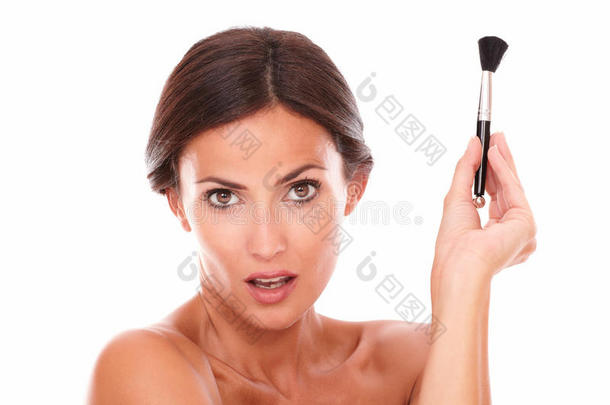 女人用化妆刷来呵护自己的脸