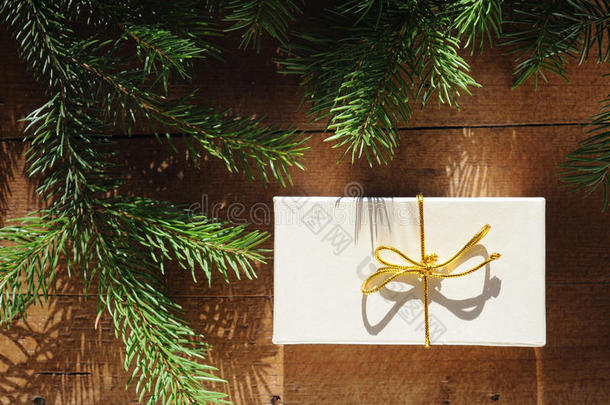 圣诞礼物和圣诞树树枝的金色礼盒