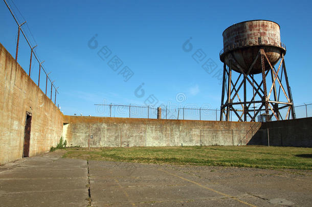 锈迹斑斑的水塔矗立在墙外，还有铁丝网