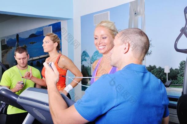 两位女士在健身房和私人健身教练一起锻炼