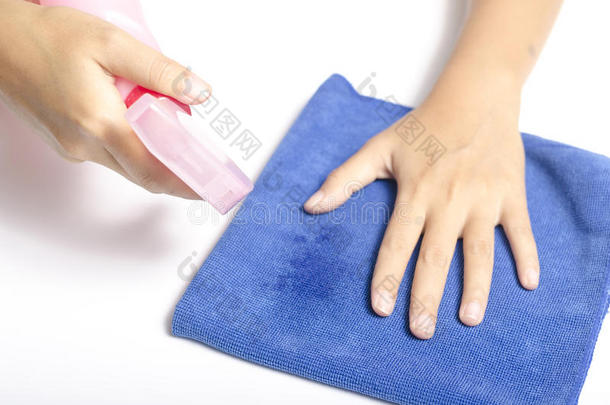 用喷雾瓶和蓝色抹布进行手部清洁