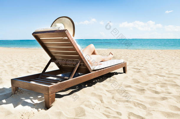 在海滩的躺椅上晒太阳的女人