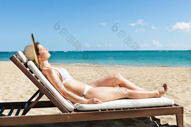 在海滩的躺椅上<strong>晒太阳</strong>的女人