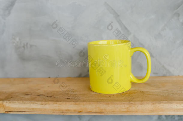 木制架子上的黄色咖啡杯