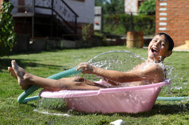 炎炎夏日，男孩拿着泼水