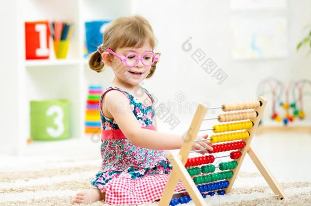 戴眼镜的女孩玩算盘玩具