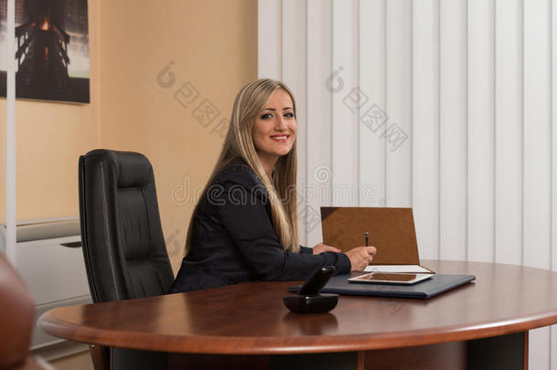 坐在办公<strong>桌</strong>前<strong>签</strong>合同的女商人