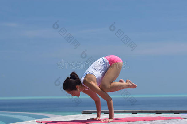 在海边练习瑜伽的亚洲华人妇女