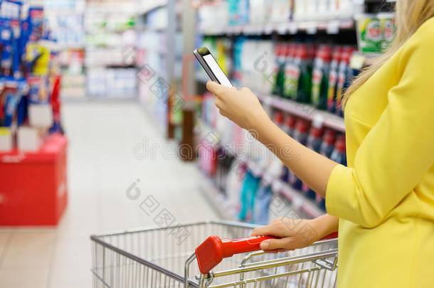 一位女士在智能手机上查看购物清单