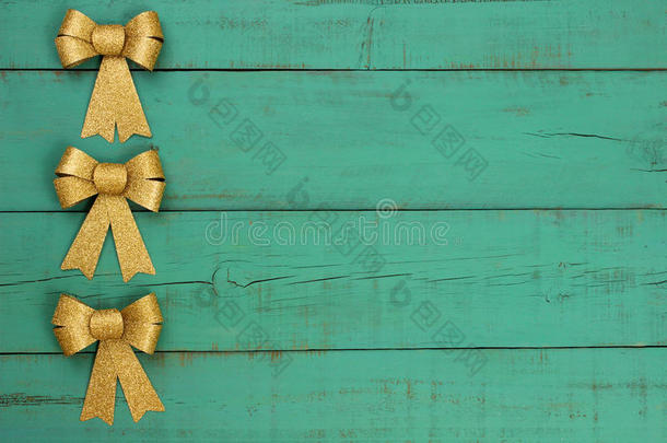 金色圣诞蝴蝶结边框古色古香的绿色风化木背景