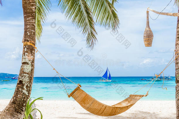 热带海滩和海洋背景的竹制吊床，暑假