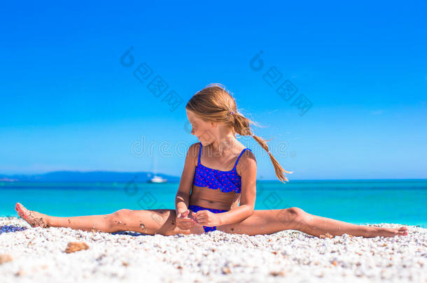 可爱可爱的女孩在白沙滩上玩得开心