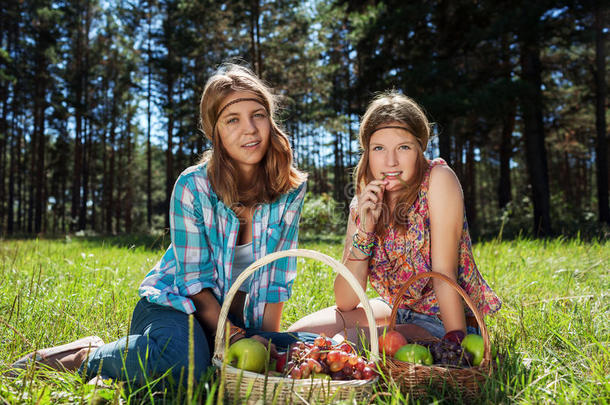 快乐的小女孩们带着一个水果篮子在大自然里