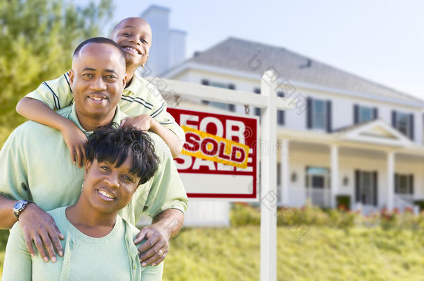 非裔美国人家庭在出售的招牌和房子前