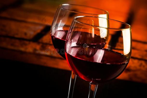 两个红葡萄酒杯放在木桌上，背景是温暖的<strong>气氛</strong>