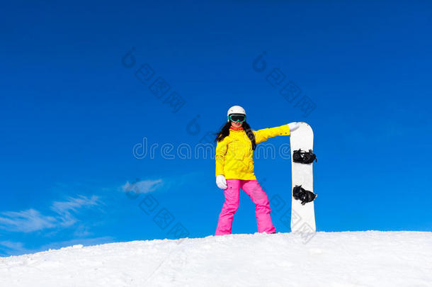 滑雪板女孩站着拿着滑雪板，雪