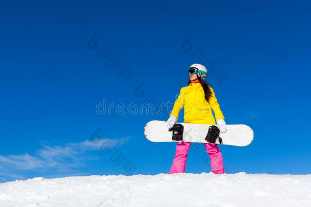 滑雪板女孩站着拿着滑雪板，雪