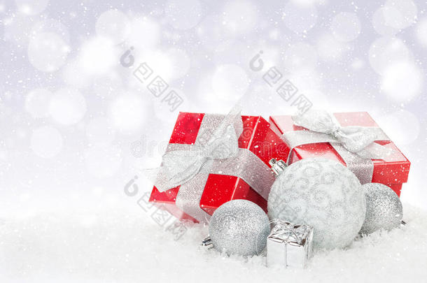 圣诞饰品和红色礼品盒在雪景背景上