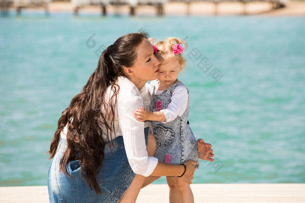 快乐的妈妈和小女孩拥抱大自然。美丽的母亲和她的孩子在户外
