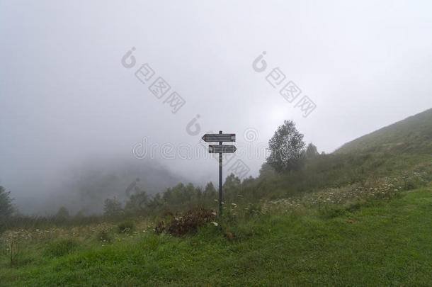 指向在浓雾笼罩的山中徒步旅行的指针。