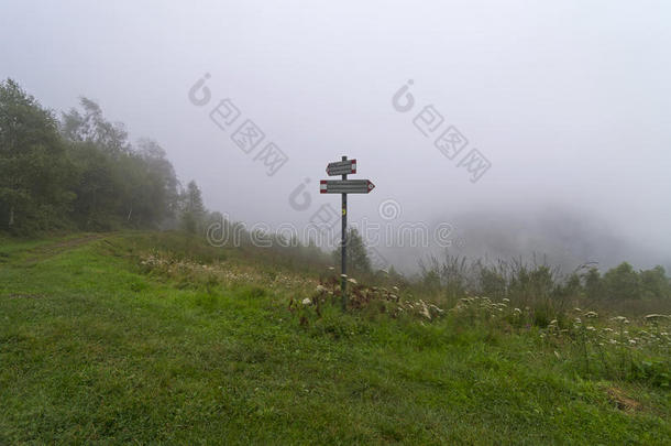指向在浓雾笼罩的山中徒步旅行的指针。
