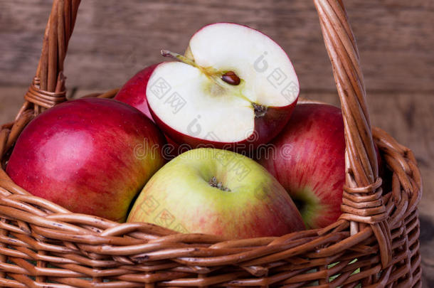 木制背景上篮子里的新鲜红苹果