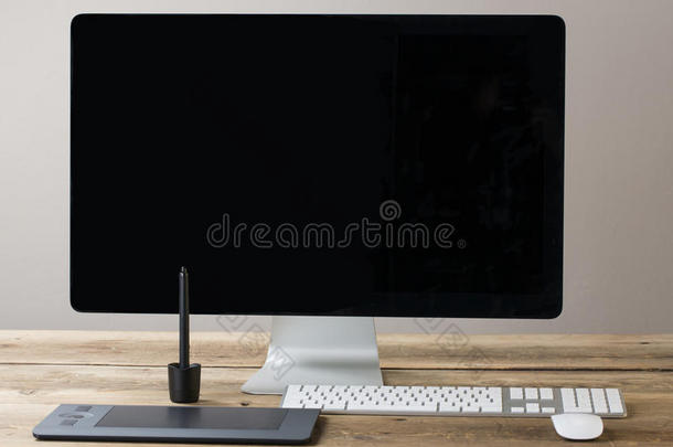 <strong>电脑</strong>屏幕和键盘鼠标放在一张木制的桌子上