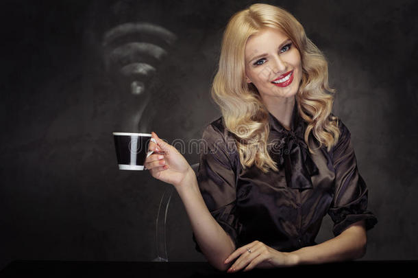 迷人的金发女人喝着带有<strong>wifi</strong>标志的蒸汽咖啡