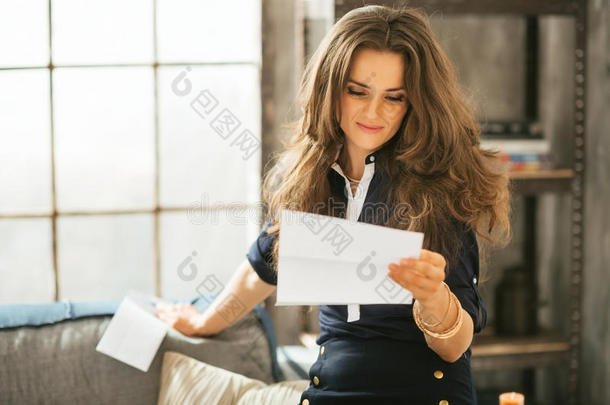 在阁楼公寓读信的年轻女子