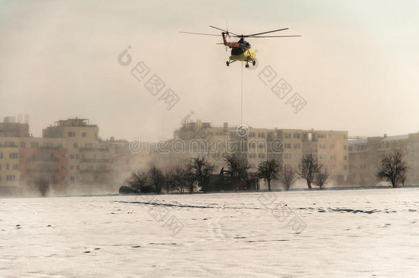 直升机载着<strong>重物</strong>在雪地上飞行
