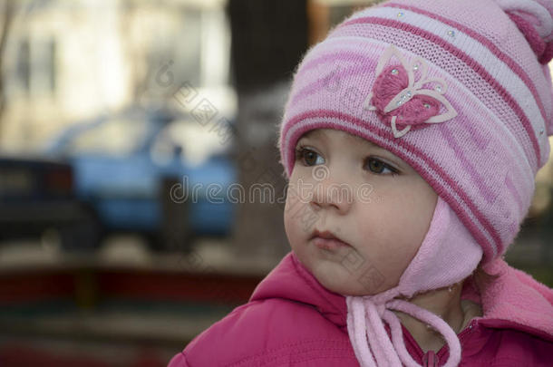 春天，一个心烦意乱的小女孩独自站在街上。