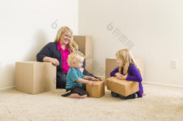 年轻的一家人在空房间里搬箱子