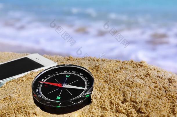 海滩上的指南针和手机