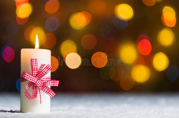 燃烧的蜡烛，在雪地里，伴随着<strong>飘散</strong>的仙女灯，背景是波基，节日的圣诞背景
